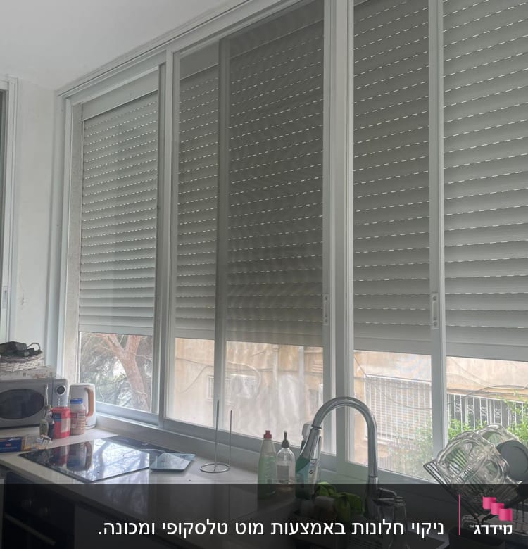 מוצרי ניקוי ליד כיור במטבח עם כלים